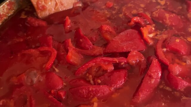 boiled peppers in tomato juice for preserving lecho. High quality 4k footage