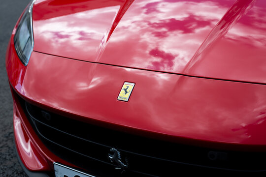 Moscow, Russia, August 6, 2025: Close up of red Ferrari hood with the iconic prancing horse logo. The glossy surface reflects the sky, symbolizing luxury, speed, and timeless Italian design