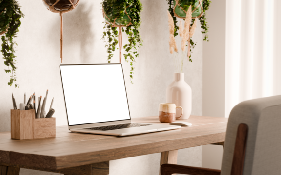 Laptop with blank screen mockup on a wooden desk - modern workspace in boho style surrounded by hanging plants and minimalist decor - Left Side Wide Perspective