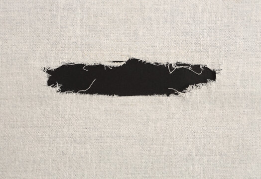 Grunge beige canvas cotton denim fabric torn empty black frame. Texture abstract background.