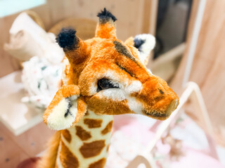 Plush giraffe toy with spotted pattern in store. Childhood fantasy, comfort, and joy through...