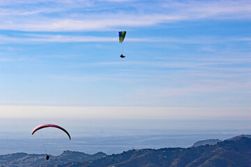 Paragliders flying above the Mediterranean coast	
