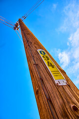 Wooden Utility Pole with Energy Identification and Power Lines Against Blue Sky