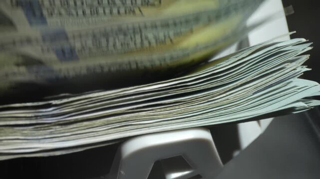Money counting. Close up currency counting machine counting dollar bills. Machine counter calculates 100 dollars banknotes in slow motion. Closeup currency count machine counting dollar banknotes.