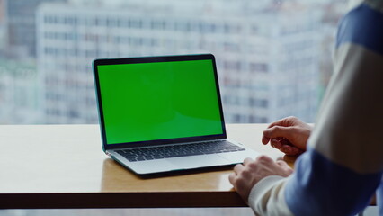 Unknown guy watching greenscreen laptop having video lesson at city view closeup