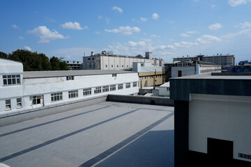 Wide view of the roofs of industrial and administrative buildings on a clear day.