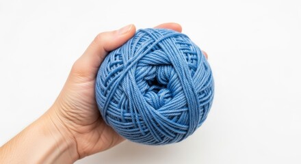 Hand holding a ball of blue yarn, Hand on white background