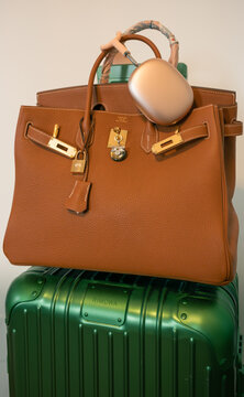 Vienna, Austria: luxury travel with green Rimowa suitcase, gold Birkin bag and Apple headphones