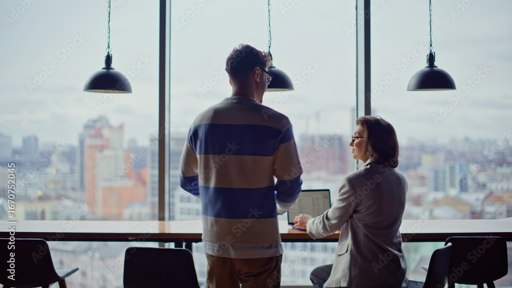 Poster man worker greeting colleague chatting at large window open space back view