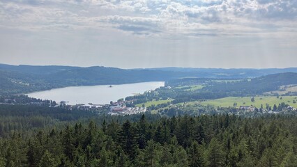 Beautiful Czech landscape with a panoramic view of the Lipno Dam surrounded by lush green forests and rolling hills.