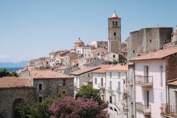 Obraz premium Old town with red roofs in South Europe. This charming cityscape features historic buildings and a tall bell tower. Perfect for travel or culture photos.