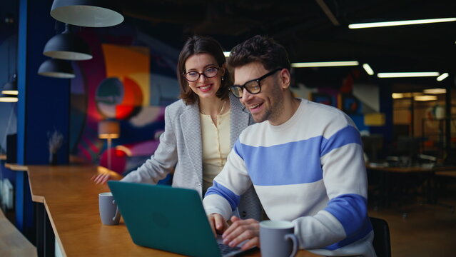 Smiling business colleagues videocalling laptop modern cafeteria counter closeup