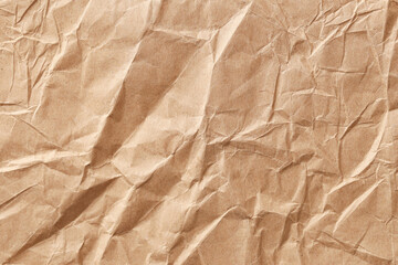 Crumpled brown paper texture background. Wrinkled kraft sheet with rough surface. Vintage packaging material detail. Empty blank backdrop for design. Recycled eco paper grunge style template.