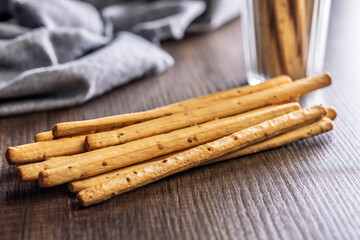 Crispy grissini breadsticks on wooden table.