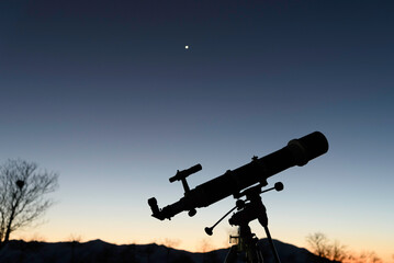 Telescope silhouette on a tripod, telescope against the night sky, telescope observing the stars at...