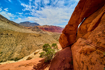 Red Rock Arch Desert Landscape and Distant Mountains under Bright Blue Sky