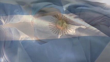 Doctor raising arms and securing mask and cap for surgery prep with transparent Argentine flag - Powered by Adobe