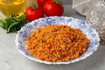 Traditional turkish bulgur pilaf with tomato sause in plate (Turkish name; meyhane pilavi)