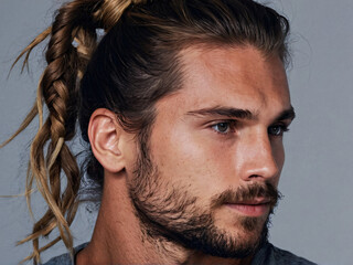 Stylish messy man bun hairstyle on Caucasian man with stubble