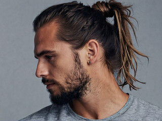 Stylish messy man bun hairstyle on Caucasian man with stubble