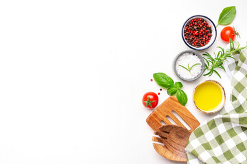 Food and cooking background, spices herbs, kitchen utensils, top view. Rose and black pepper, fresh rosemary, basil, tomatoes, olive oil and sea salt on white table