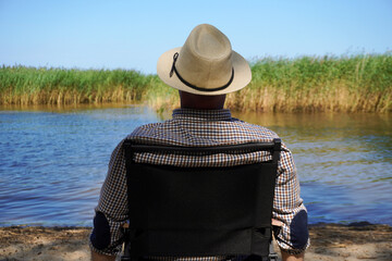 man relaxing by the river in summer, enjoying peaceful nature