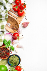 Food and spice background with herbs, turmeric, dried herbs, chili powder and kitchen utensils, white table, top view