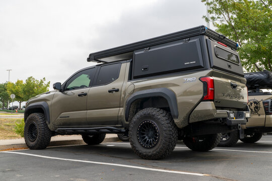 Loveland, CO, USA - August 22, 2025: 4th generation Toyota Tacoma truck in TRD Pro trim,  i-Force Max hybrid powertrain, set up for overlanding with Super Pacific camper.