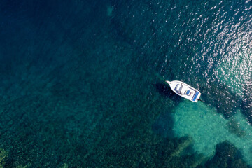 Drone aerial scenery of motorboat moored in the shallow sea.