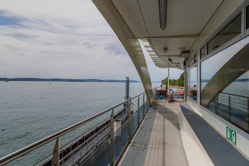 Ferry deck with benches and lake view under cloudy sky