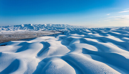 aerial view of blue and white snow covered dunes