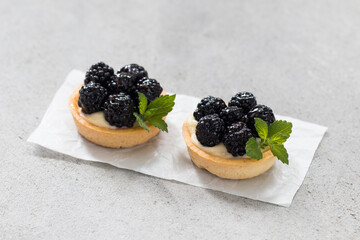 Two Blueberry tartlets. With custard. Light background. Close up