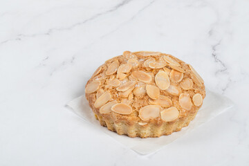 Almond cake. On a paper. Light background. Copy space	