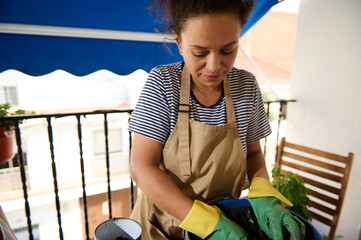 Woman Gardening on Balcony with Focus on Sustainable Living and Plants