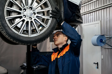 Portrait Shot of a Handsome Mechanic Working on a Vehicle in a Car Service. Professional Repairman...