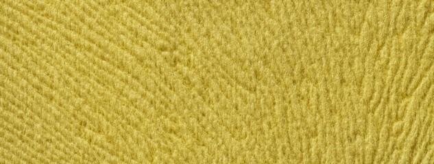 Yellow background from soft fluffy textile material macro. Texture of golden plush fabric backdrop. Wavy pattern