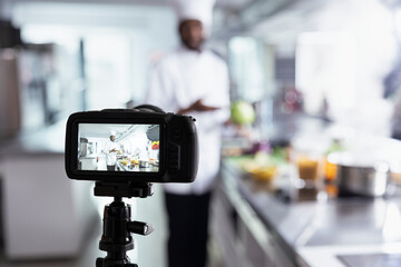 African american chef filming a culinary master class for beginners, providing essential cooking skills and other techniques. Remote course held in a kitchen, making gourmet training on the web.
