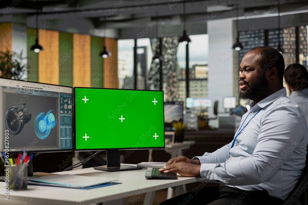 Poster worker reviews turbine data on chroma key computer to save energy and lower costs. sustainability ex