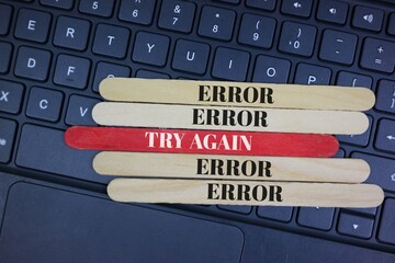 Error Messages and try again on Colorful Wooden Sticks on a Computer Keyboard.