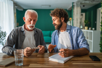 Doctor explaining medicine dosage to senior man at home