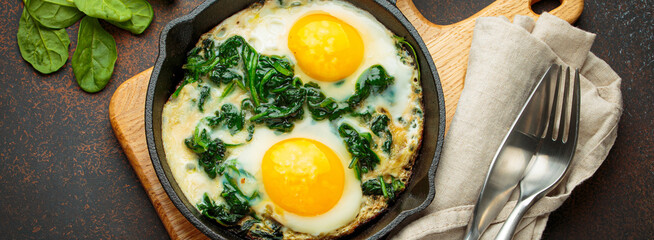 Healthy spinach omelette in a cast iron pan is ready to be served for a nutritious and delicious...