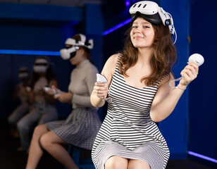 Cheerful teen girl with VR headset and controllers, eagerly anticipating virtual reality experience...