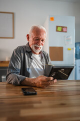 Senior man drinking coffee and looking at photo frame with nostalgia