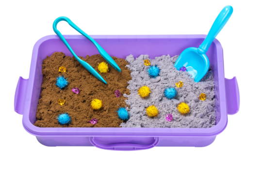 Kinetic sand of two colors with pompoms, stones, scoop and tongs in plastic container isolated on white background