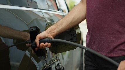 Close up of person opening vehicle inlet port of emission free electric automobile to charge it....