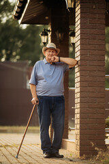Grandfather in a hat. Portrait of a very old Caucasian man. Portrait: elderly, lonely, elderly, with many wrinkles on his face. Close-up of a thoughtful old man standing alone outdoors.
