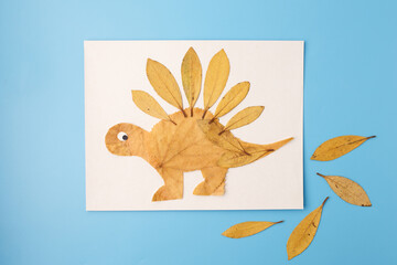 autumn dinosaur collage from leaves on soft background, creative eco artwork for kids craft, ideal...