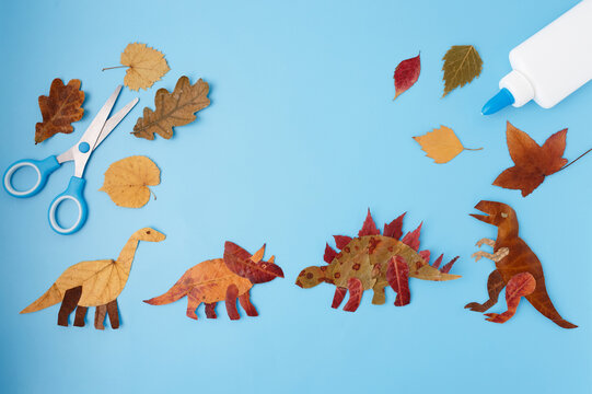 Flat lay with scissors glue stick and autumn leaves on blue copy space background education and creative craft project design for banner school advertising seasonal sales stationery business,