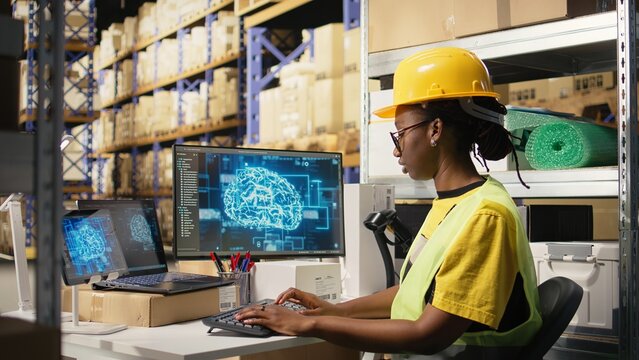 African american woman uses AI deep learning software for e-commerce automation, working in distribution hub with neural networks brain managing tracking software. Data science. Camera A.