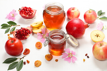 Creative composition for the Jewish holiday Ro Hashanah with a place for congratulations. Layout with traditional symbols of the Jewish New Year, template with honey, apples, pomegranate and flowers